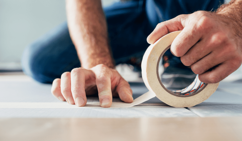 Person using masking tape on floor