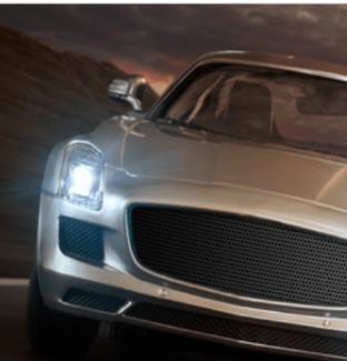 Front on silver car with headlights on